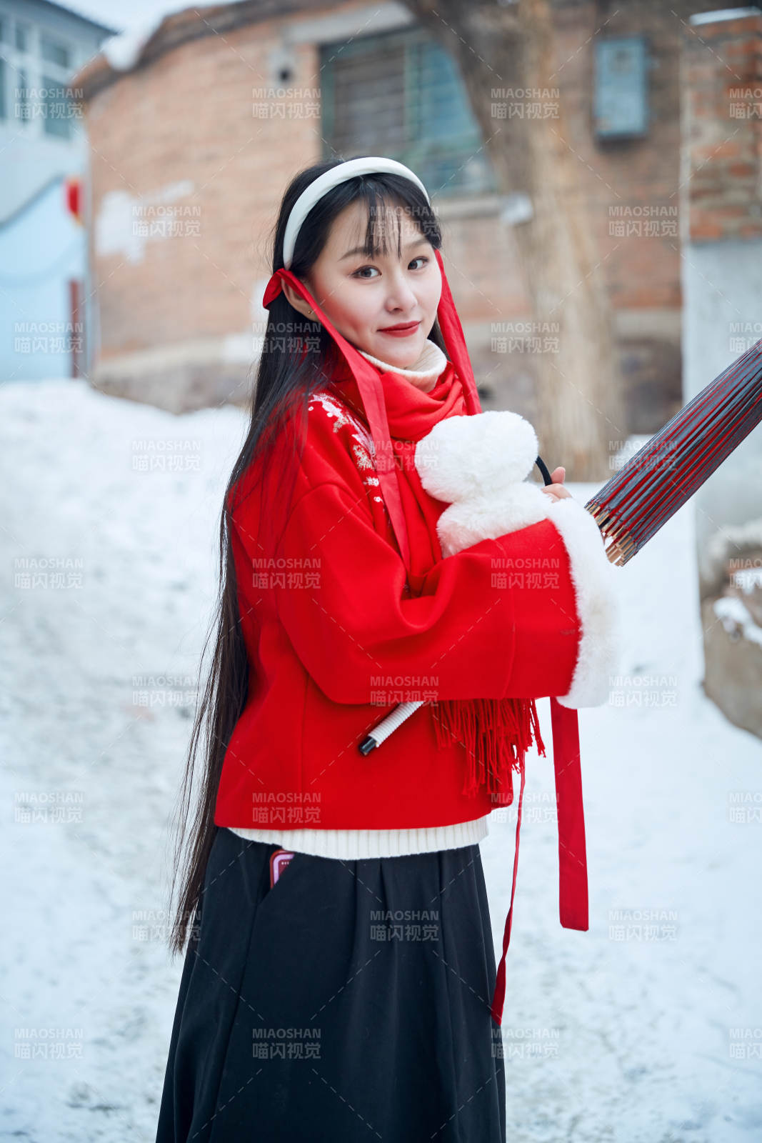雪后在老城古巷穿著喜慶服飾的亞洲少女