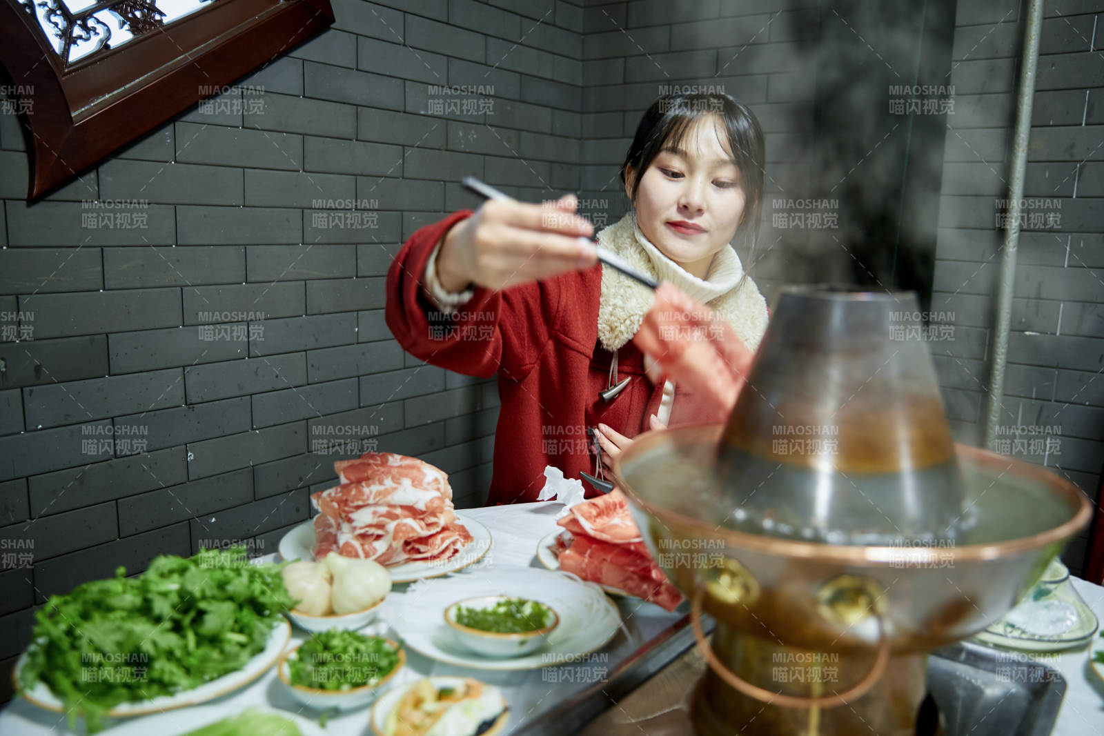 在飯店吃傳統(tǒng)銅鍋涮肉的亞洲少女