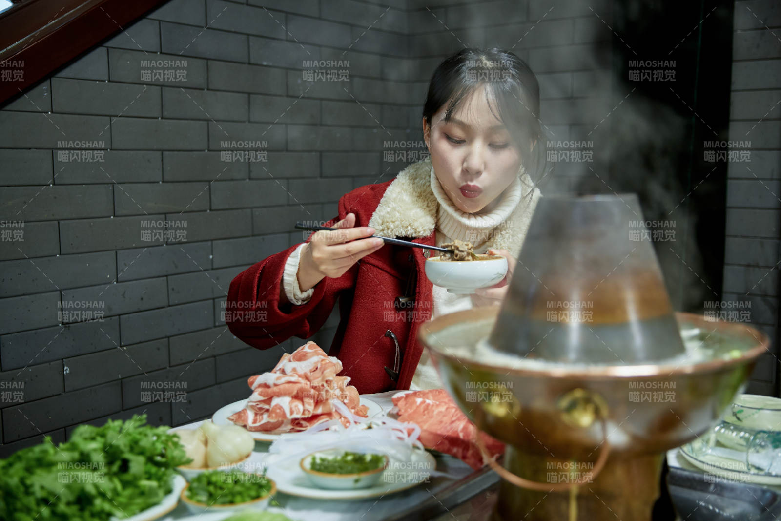 在飯店吃傳統(tǒng)銅鍋涮肉的亞洲少女