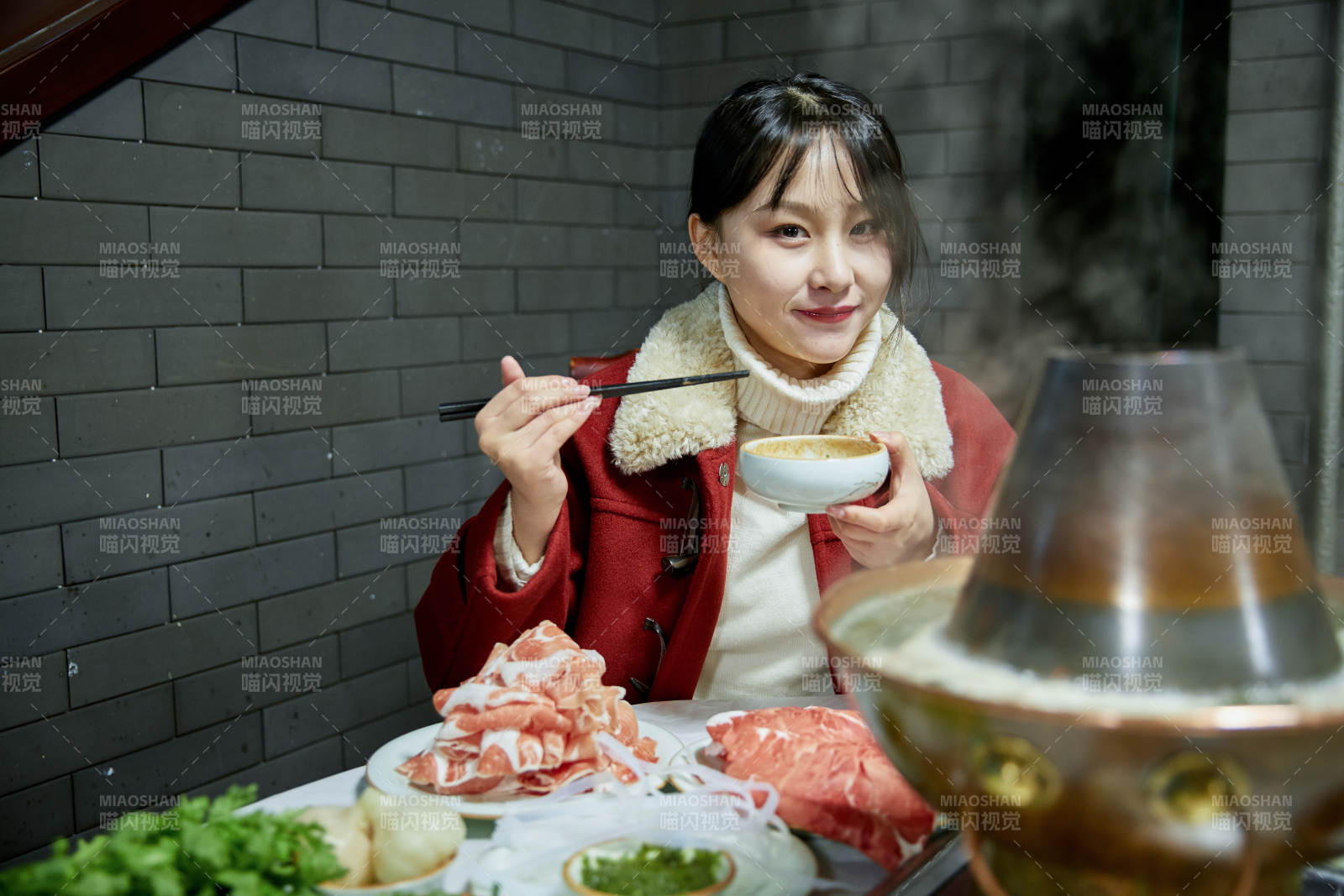 在飯店吃傳統銅鍋涮肉的亞洲少女