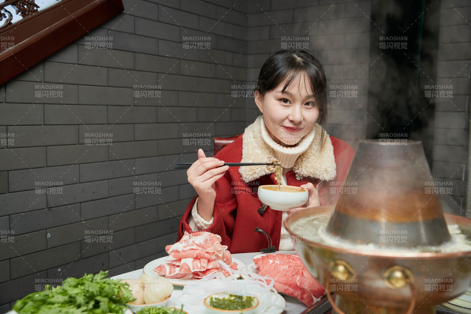 在飯店吃傳統(tǒng)銅鍋涮肉的亞洲少女