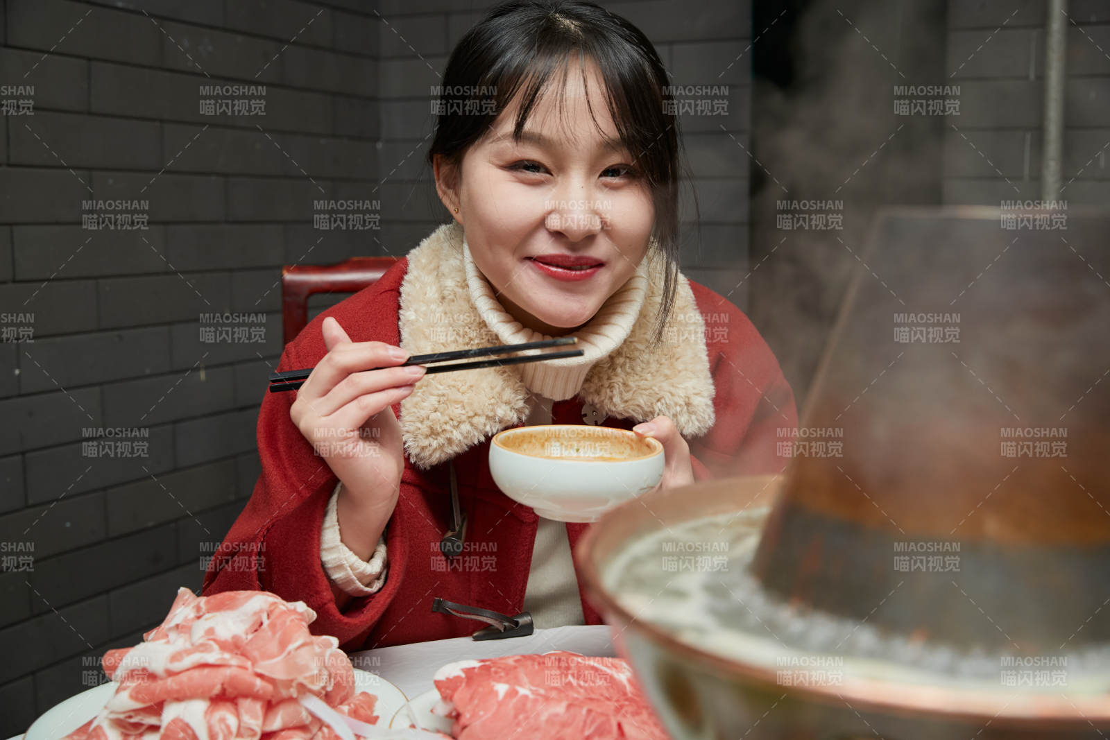 在飯店吃傳統(tǒng)銅鍋涮肉的亞洲少女