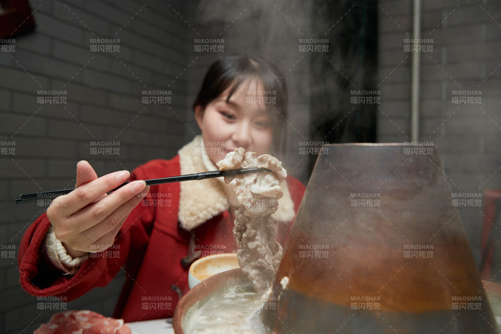 在飯店吃傳統(tǒng)銅鍋涮肉的亞洲少女