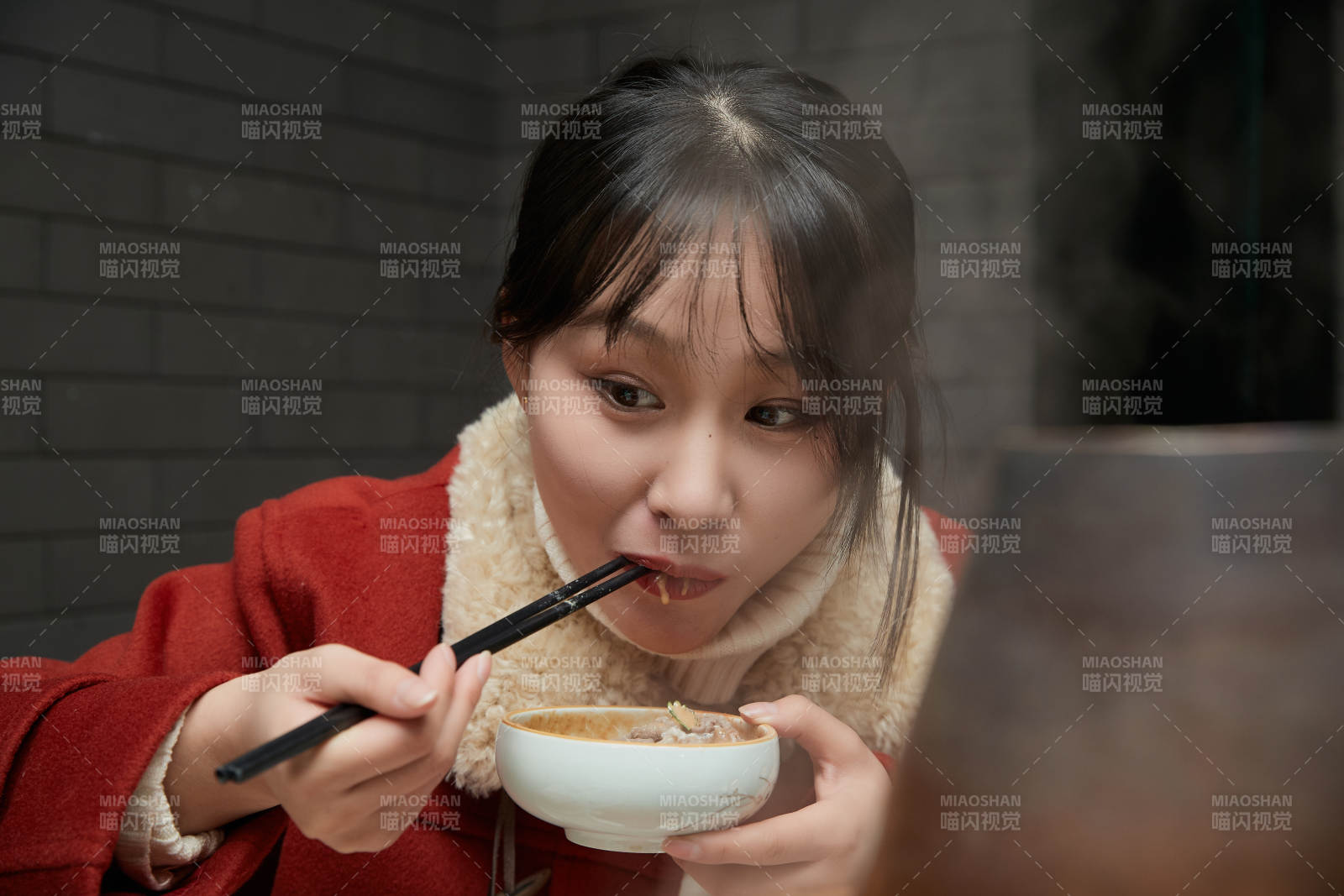 在飯店吃傳統(tǒng)銅鍋涮肉的亞洲少女