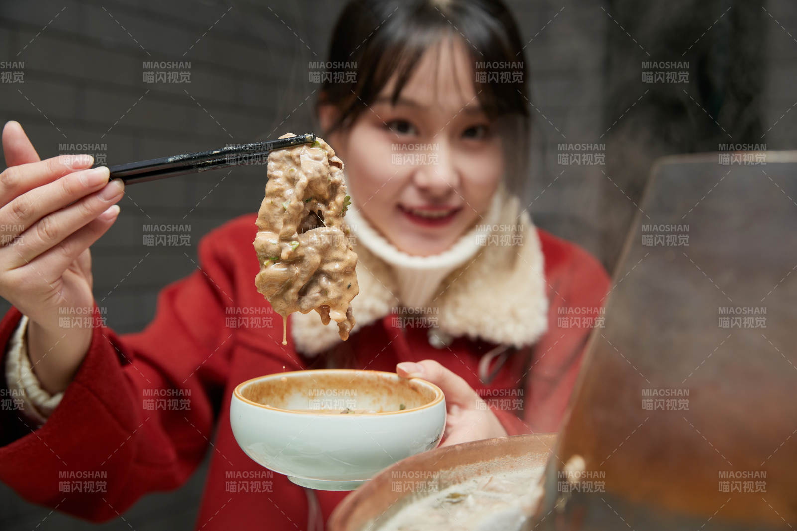 在飯店吃傳統(tǒng)銅鍋涮肉的亞洲少女