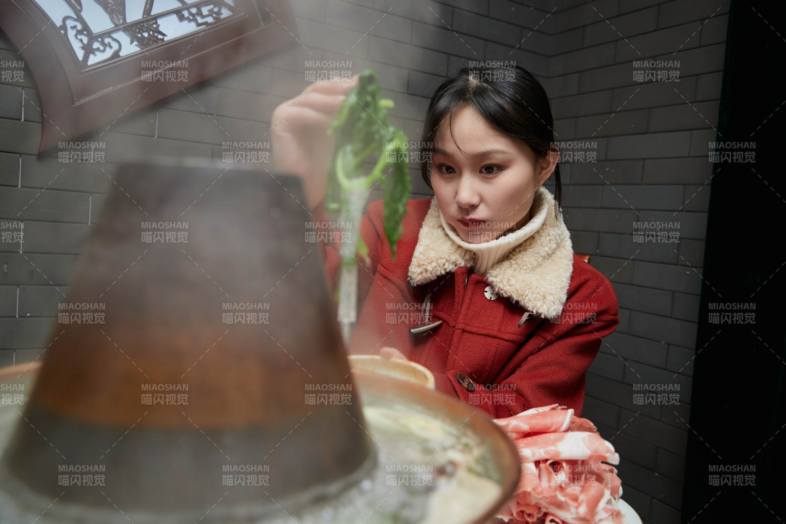 在飯店吃傳統銅鍋涮肉的亞洲少女