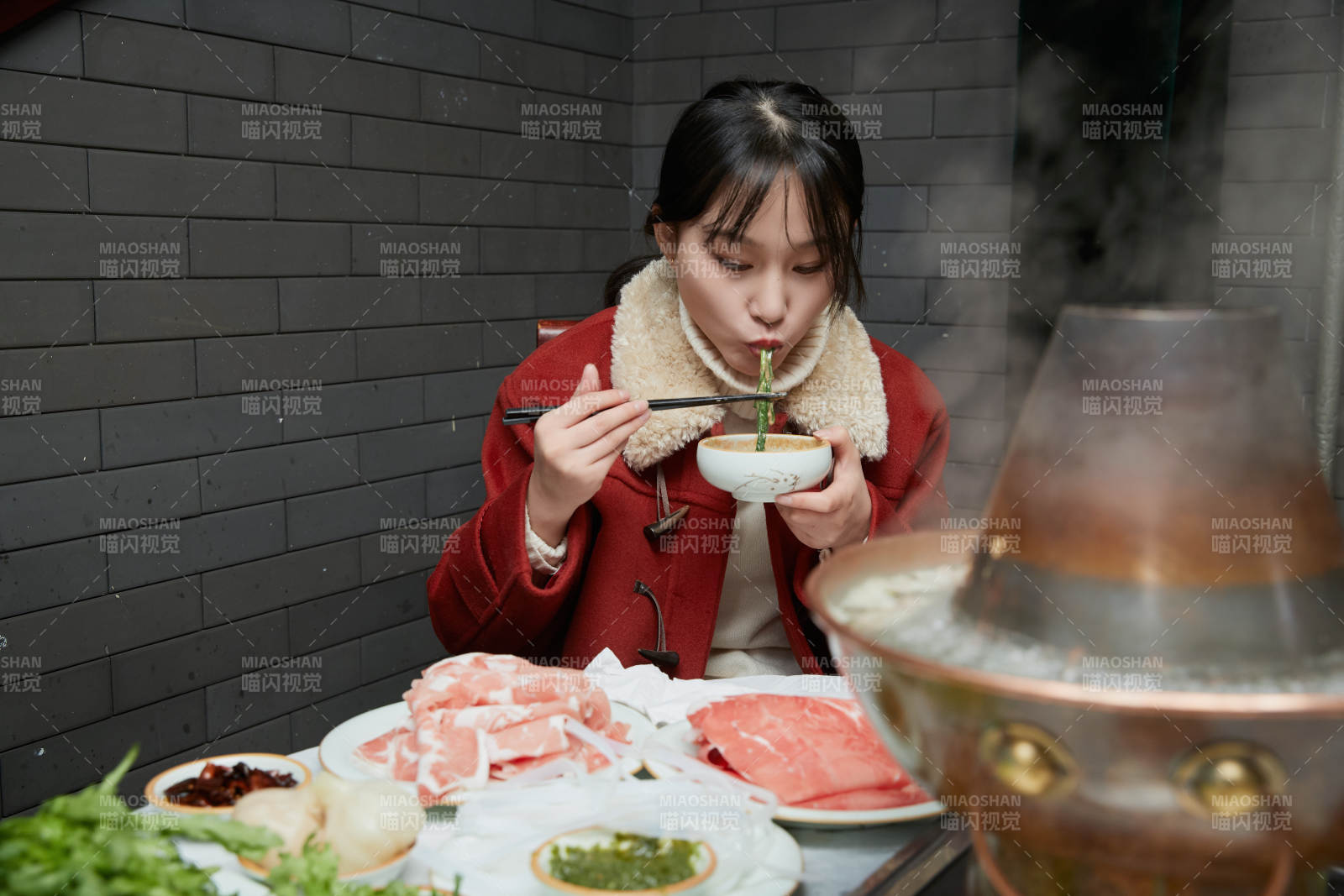 在飯店吃傳統銅鍋涮肉的亞洲少女