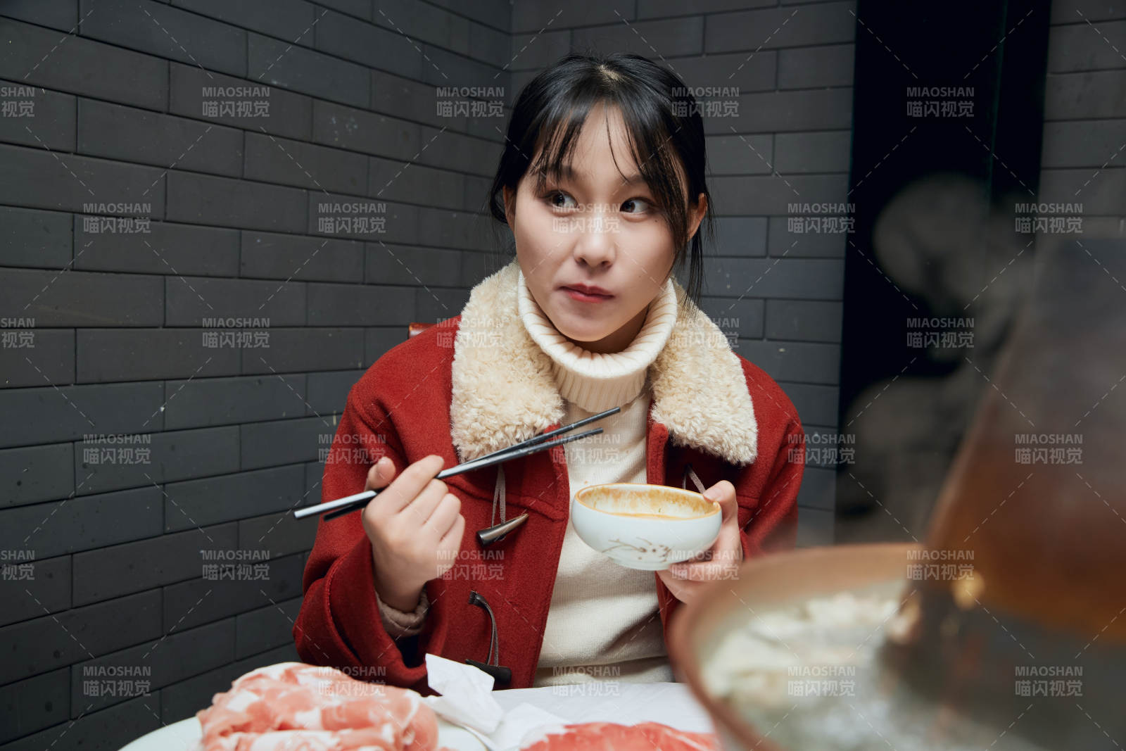 在飯店吃傳統銅鍋涮肉的亞洲少女