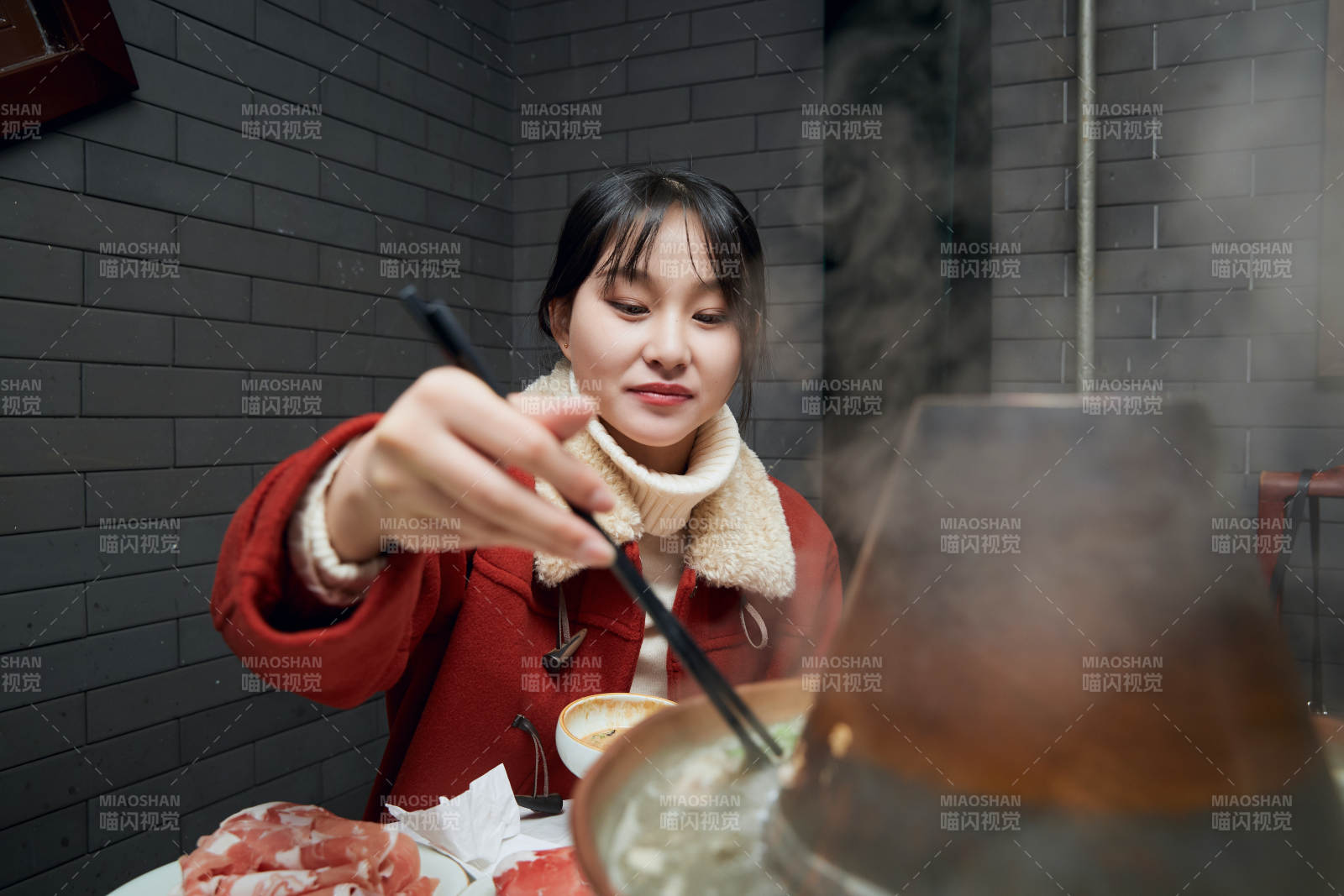 在飯店吃傳統(tǒng)銅鍋涮肉的亞洲少女