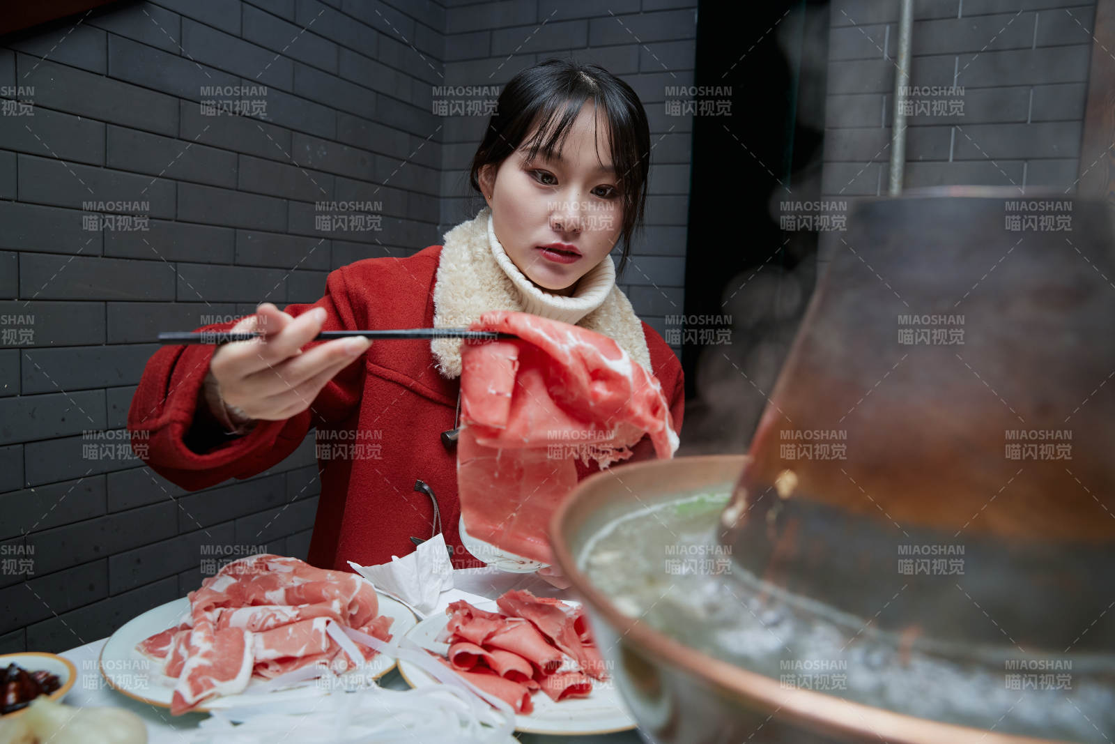 在飯店吃傳統銅鍋涮肉的亞洲少女