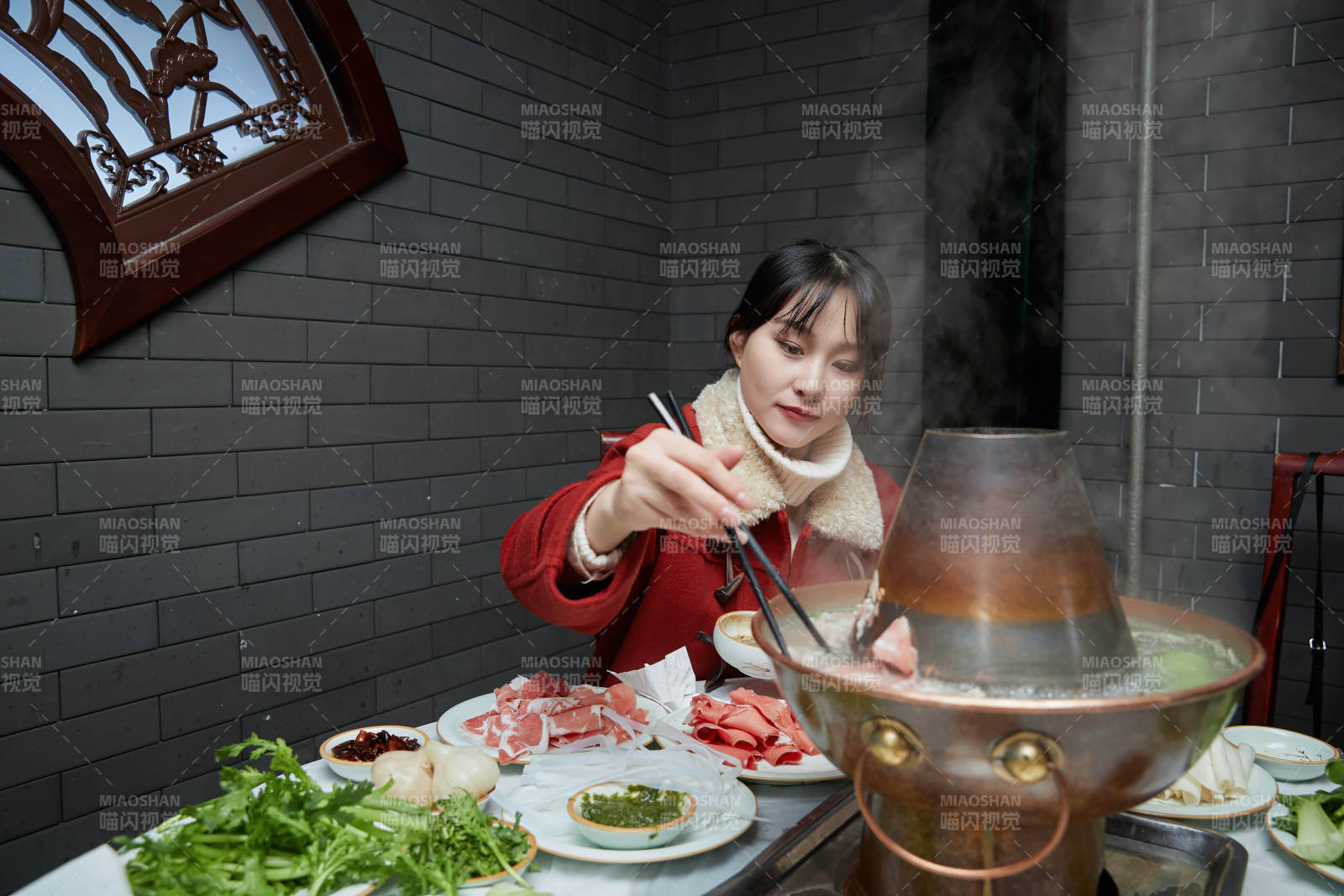 在飯店吃傳統銅鍋涮肉的亞洲少女