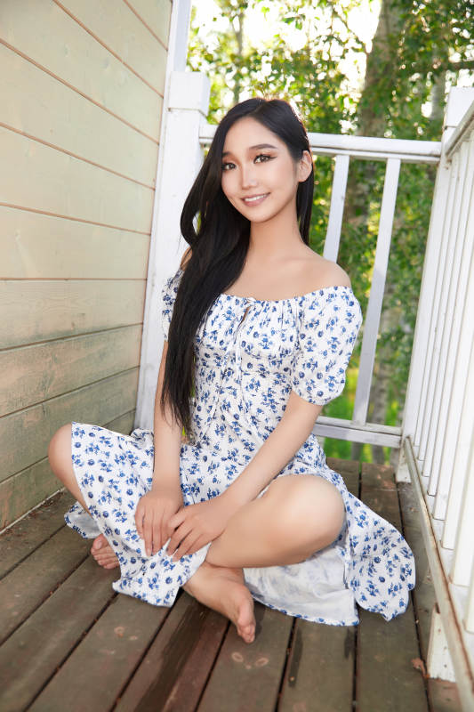 盛夏在别墅阳台上拍照的亚洲美女