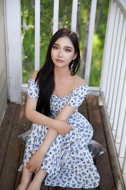 盛夏在别墅阳台上拍照的亚洲美女