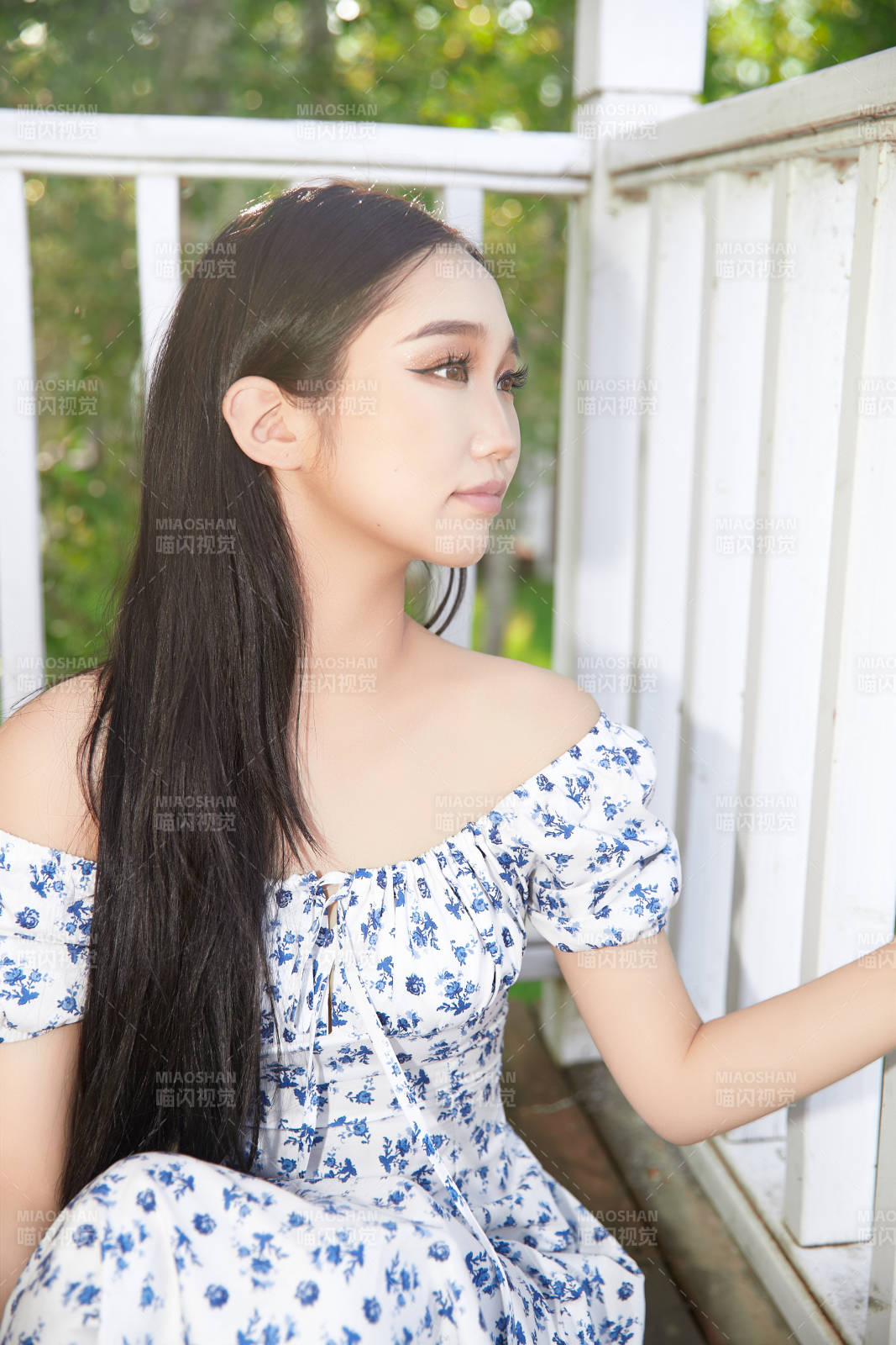 盛夏在别墅阳台上拍照的亚洲美女