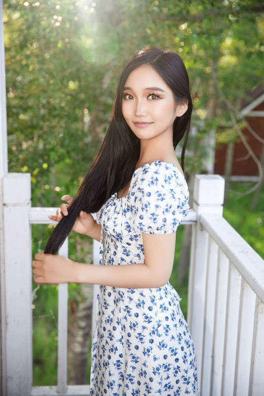 盛夏在别墅阳台上拍照的亚洲美女