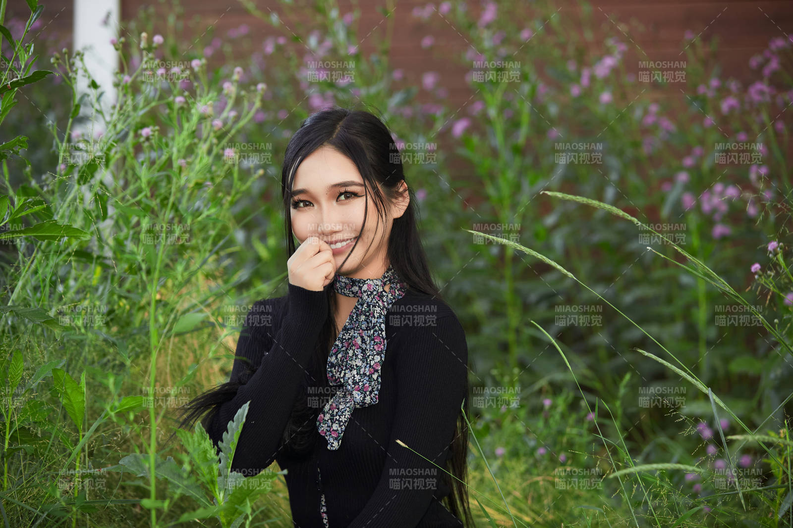 盛夏夕陽照射下花叢草地中的亞洲美女