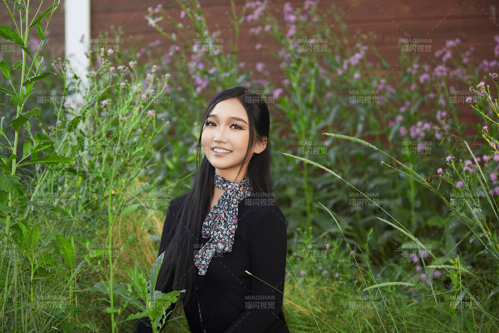 盛夏夕陽照射下花叢草地中的亞洲美女