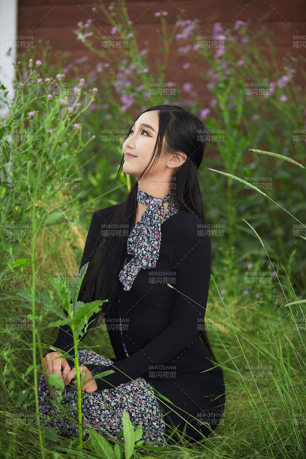 盛夏夕阳照射下花丛草地中的亚洲美女