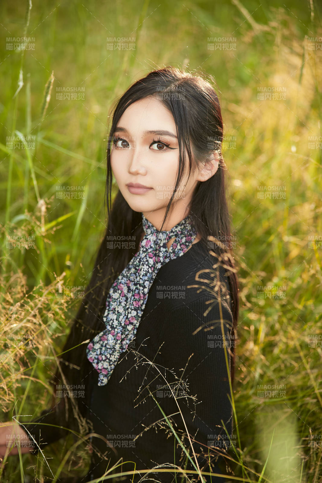 盛夏夕阳照射下花丛草地中的亚洲美女