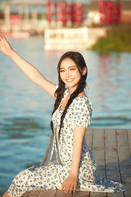 夏日湖畔水边游玩拍照的亚洲美女