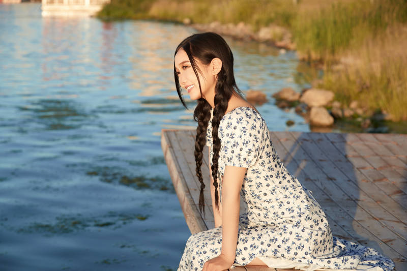 夏日湖畔水边游玩拍照的亚洲美女