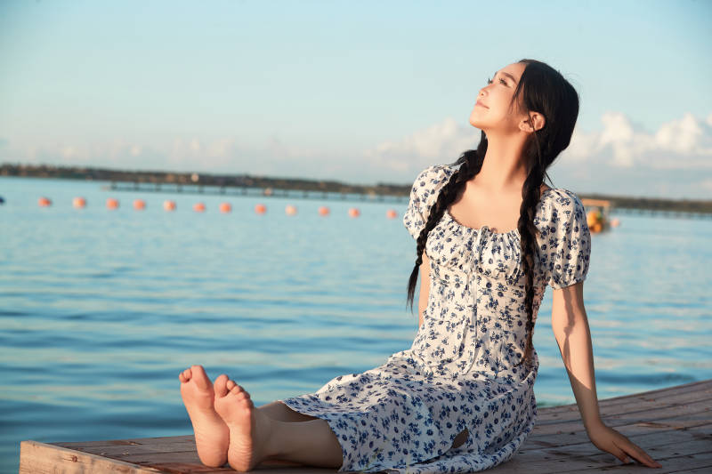 夏日湖畔水边游玩拍照的亚洲美女
