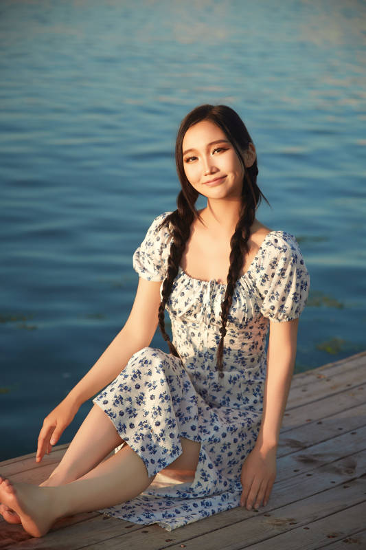 夏日湖畔水边游玩拍照的亚洲美女