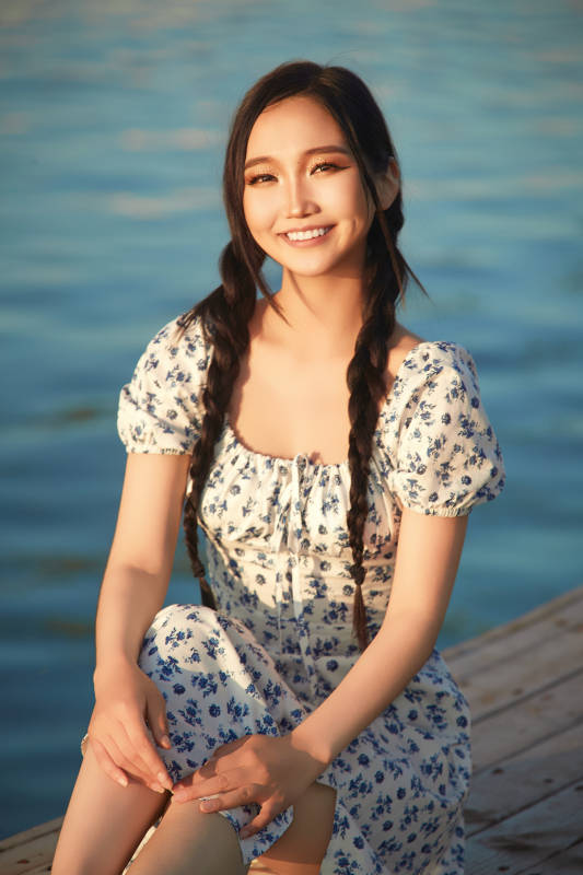 夏日湖畔水边游玩拍照的亚洲美女