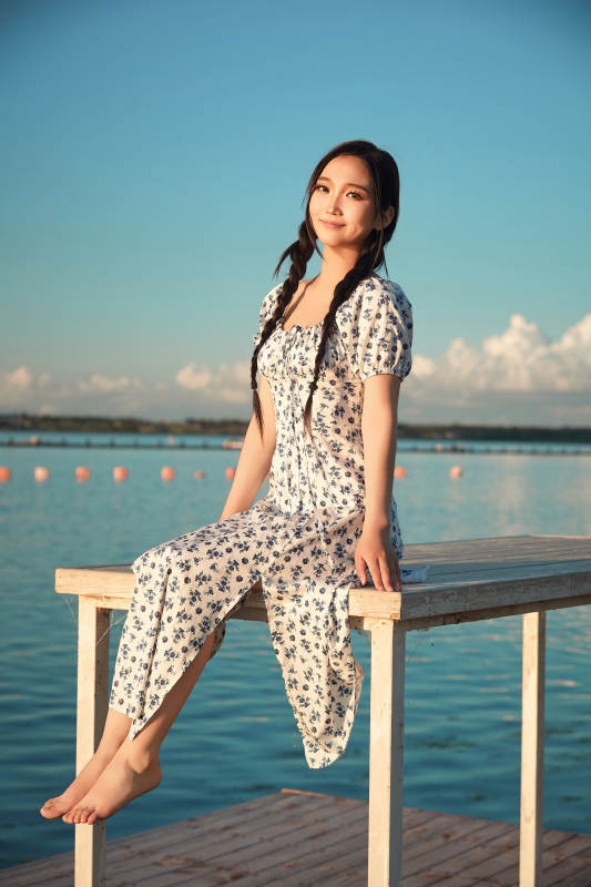 夏日湖畔水边游玩拍照的亚洲美女