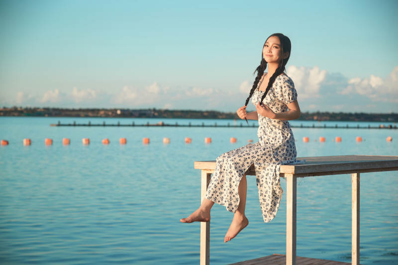 夏日湖畔水边游玩拍照的亚洲美女