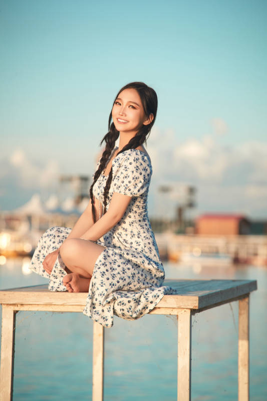 夏日湖畔水边游玩拍照的亚洲美女