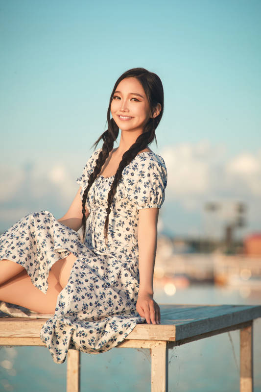 夏日湖畔水边游玩拍照的亚洲美女