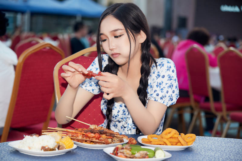 在户外冷餐自助餐会大吃特吃的美女