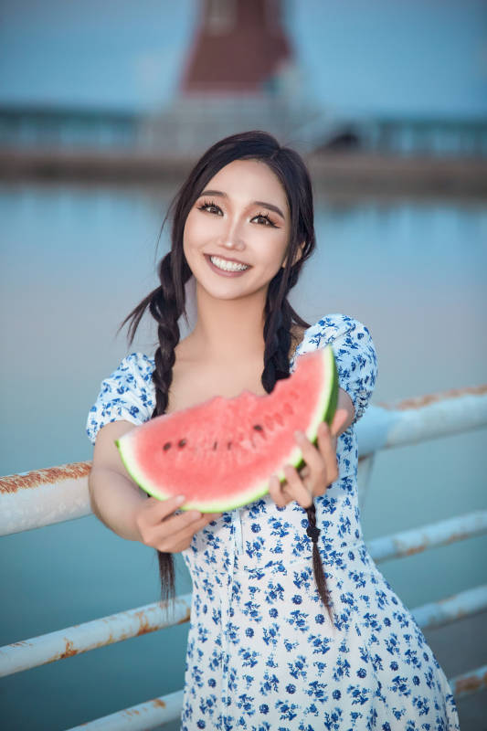 夏天在公园湖边开心吃西瓜的美女