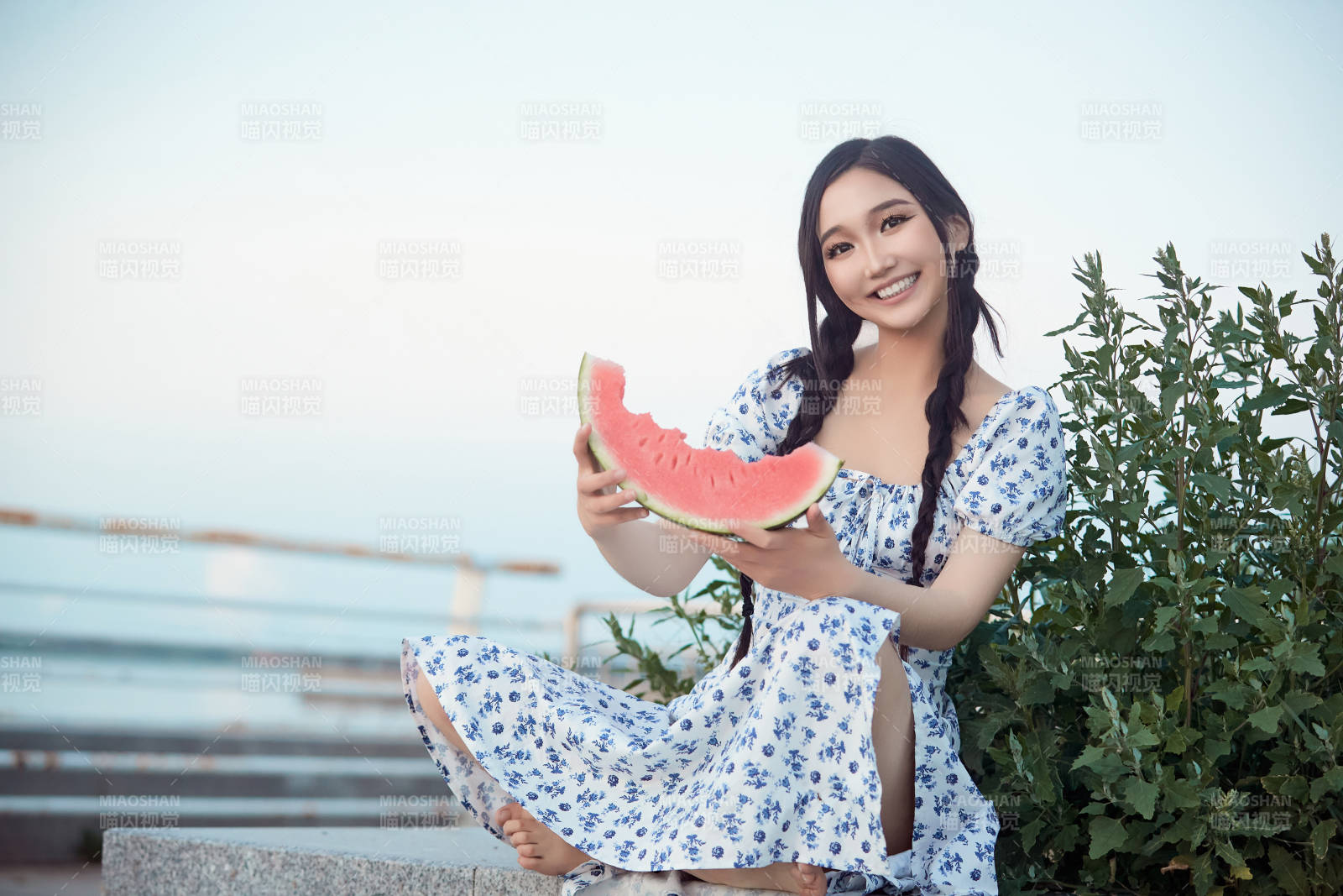 夏天在公園湖邊開心吃西瓜的美女