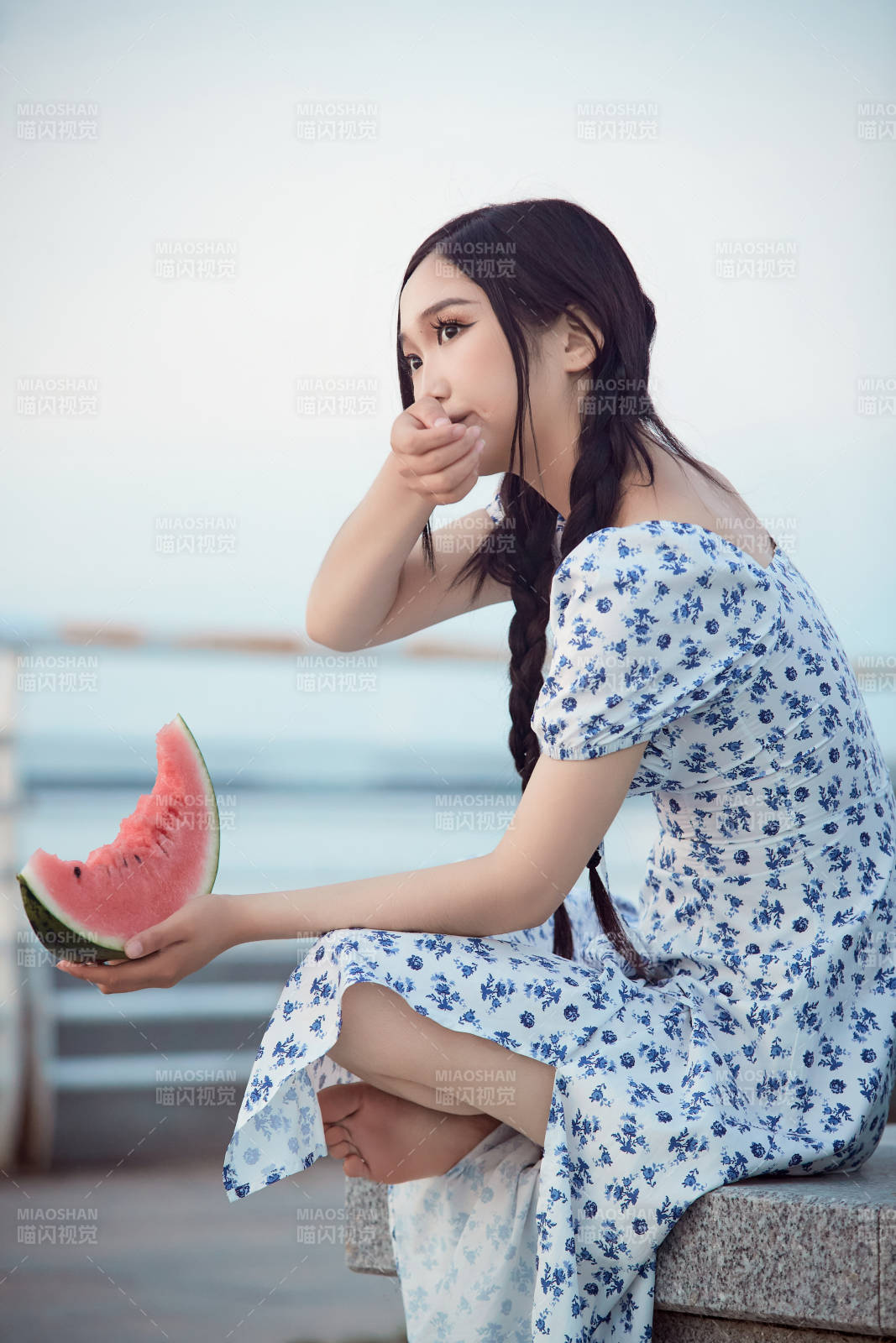 夏天在公園湖邊開心吃西瓜的美女