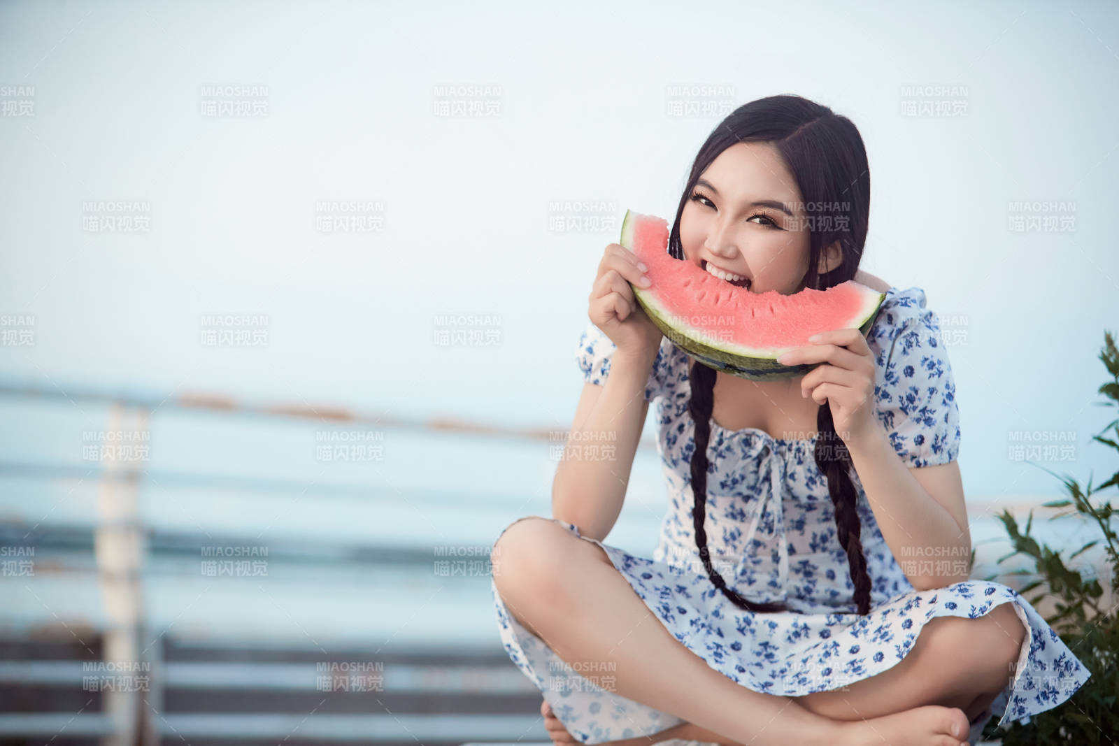 夏天在公園湖邊開心吃西瓜的美女