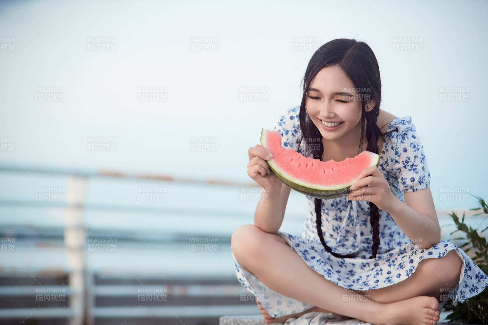 夏天在公園湖邊開心吃西瓜的美女