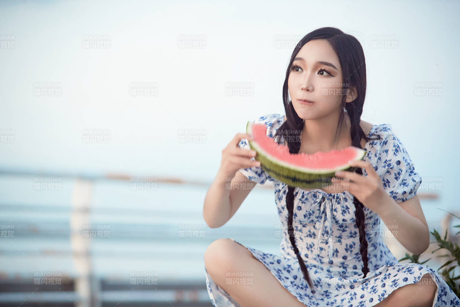 夏天在公园湖边开心吃西瓜的美女