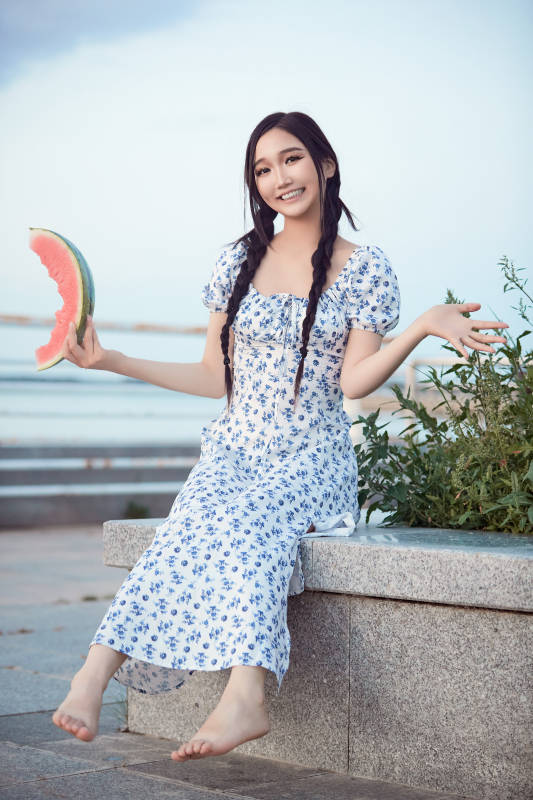 夏天在公园湖边开心吃西瓜的美女