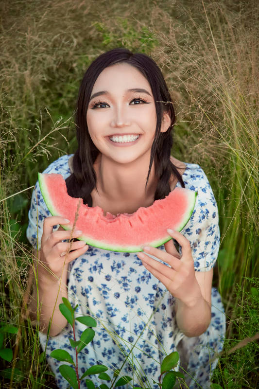 夏天在公园湖边开心吃西瓜的美女