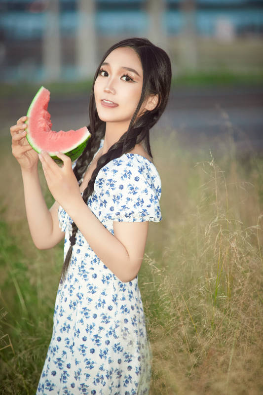 夏天在公园湖边开心吃西瓜的美女