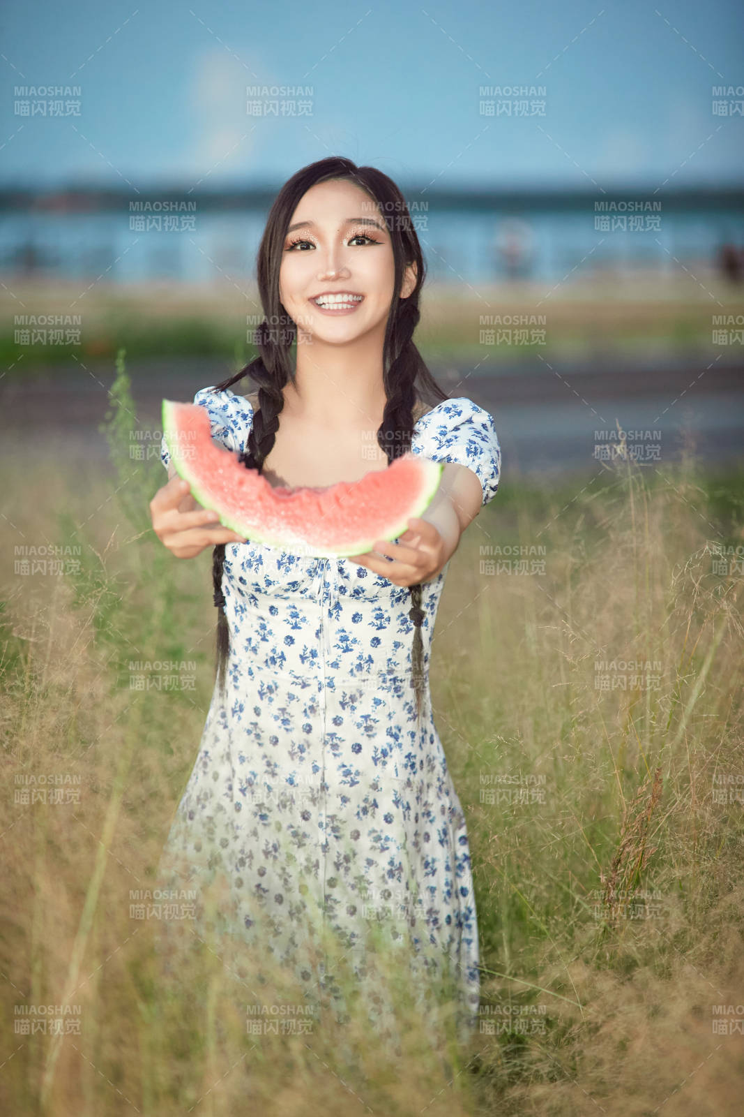 夏天在公园湖边开心吃西瓜的美女