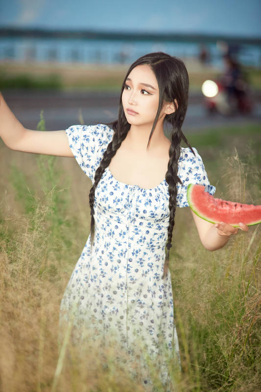 夏天在公园湖边开心吃西瓜的美女