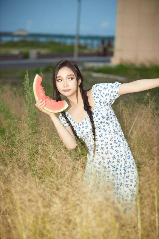 夏天在公园湖边开心吃西瓜的美女