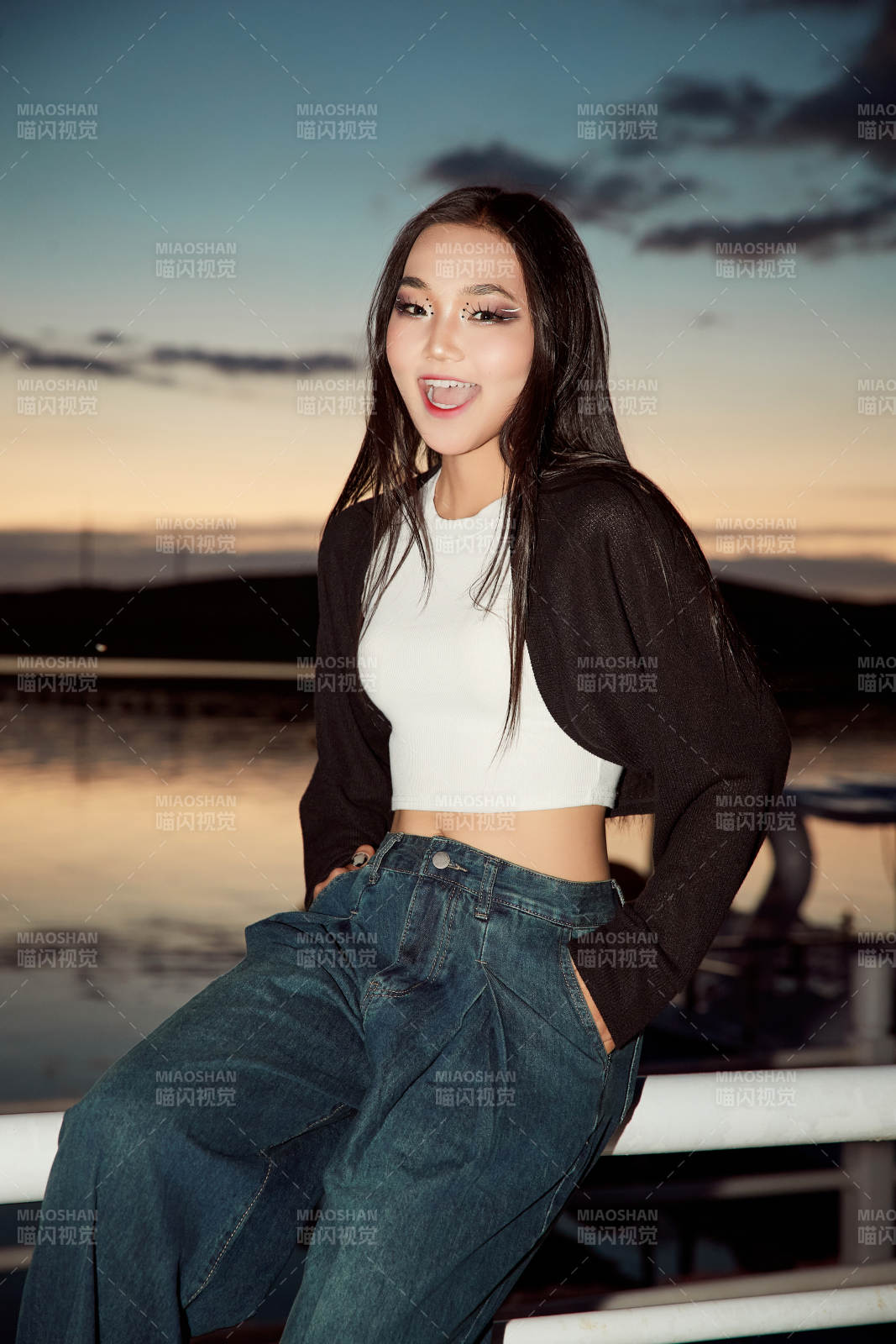 傍晚在湖邊欣賞風景拍照的亞洲美女