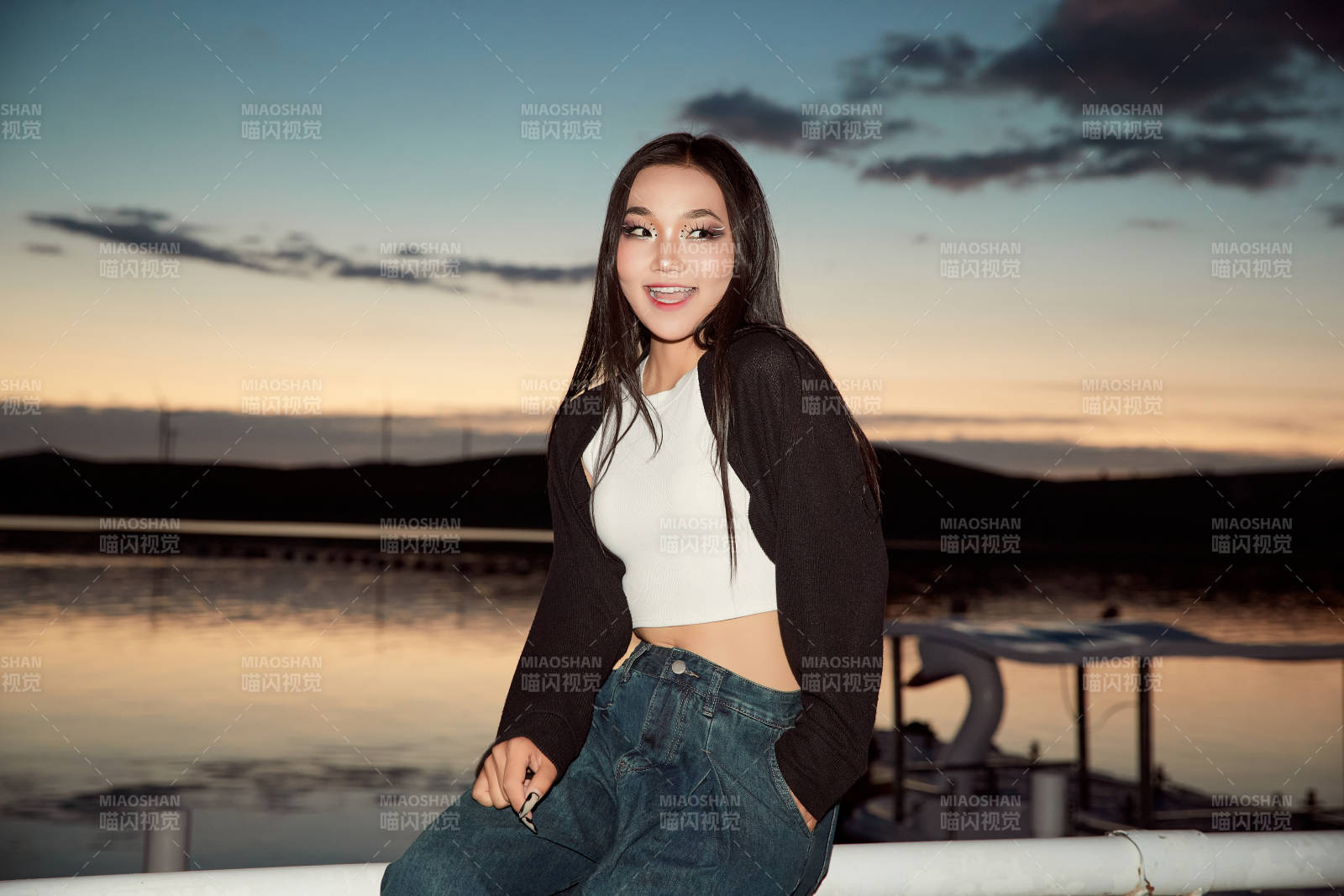 傍晚在湖邊欣賞風景拍照的亞洲美女