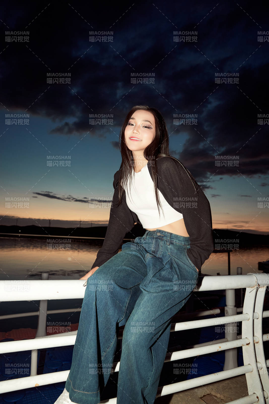 傍晚在湖邊欣賞風(fēng)景拍照的亞洲美女