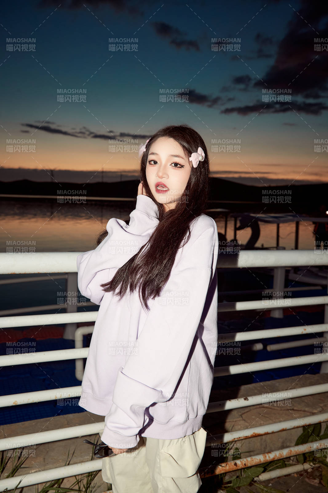 傍晚在湖边欣赏风景拍照的亚洲美女