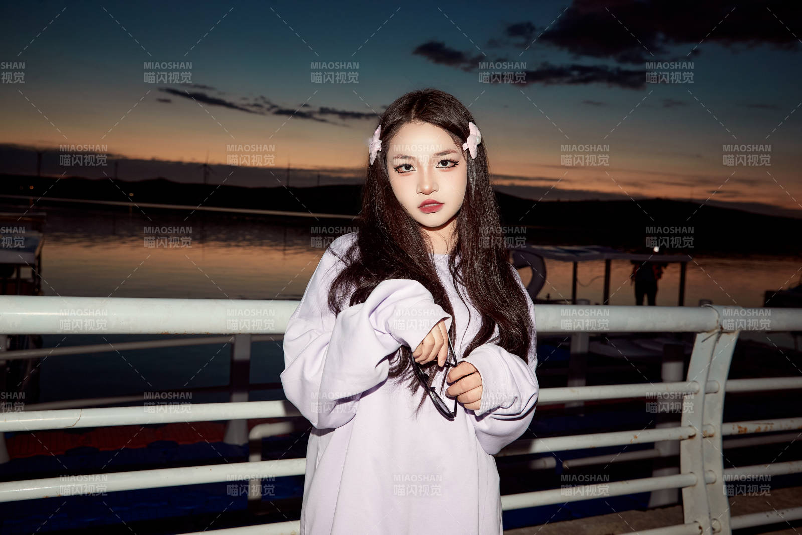 傍晚在湖邊欣賞風景拍照的亞洲美女